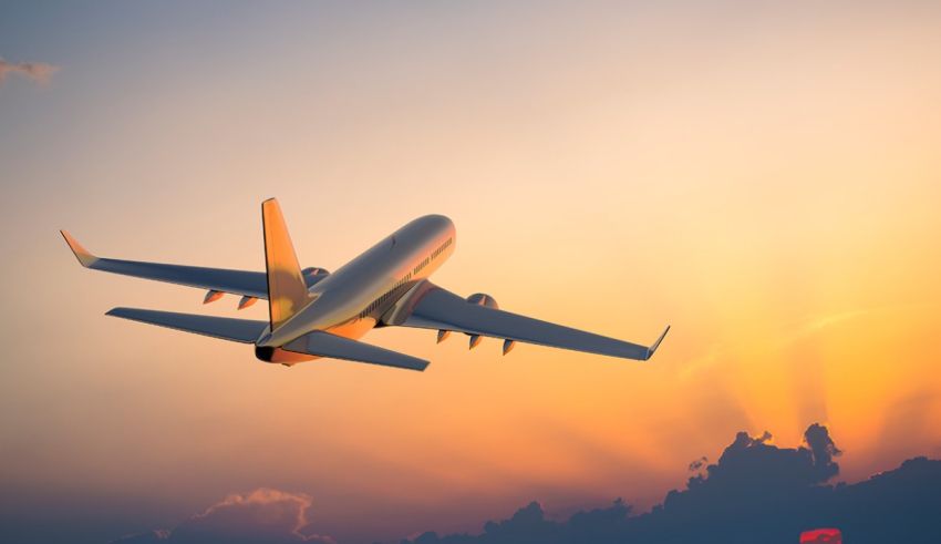 An airplane flying in the sky at sunset.