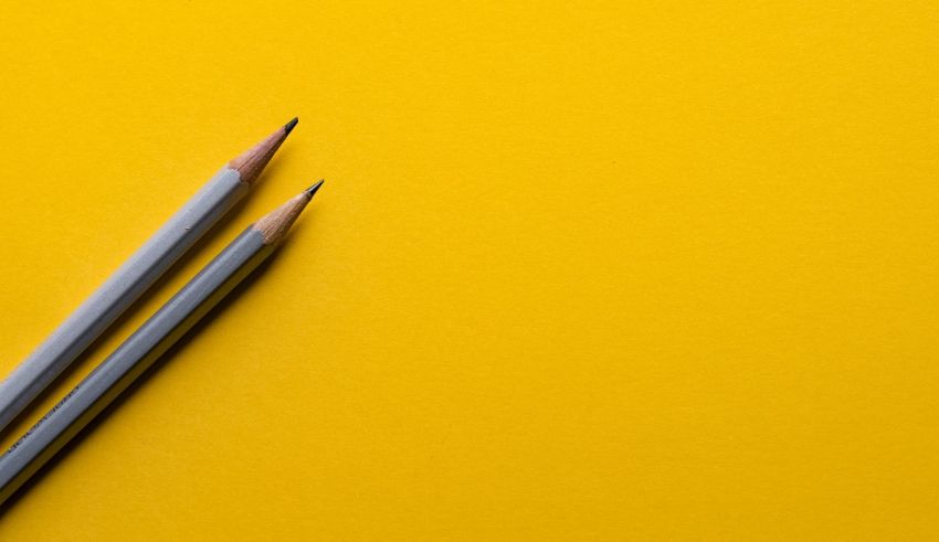 Two pencils on a yellow background.