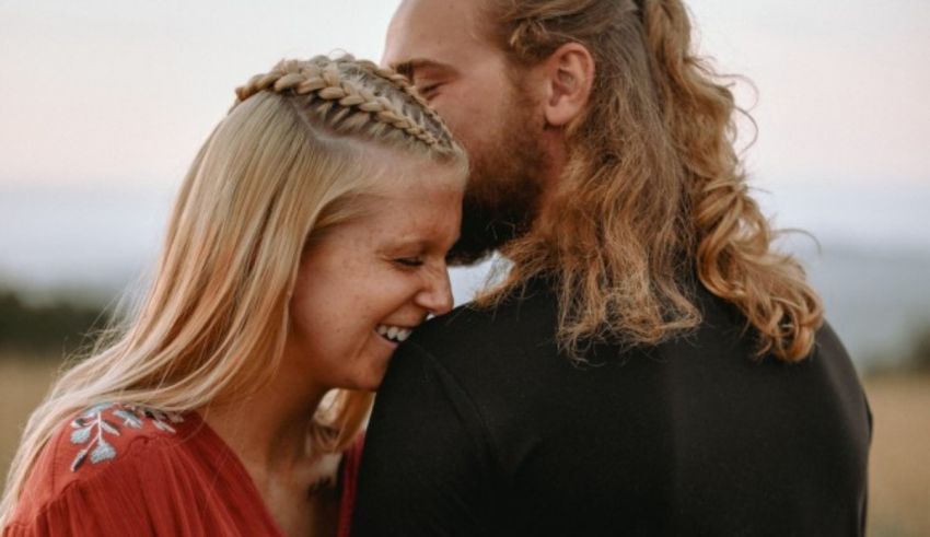 A man and woman hugging in the middle of a field.