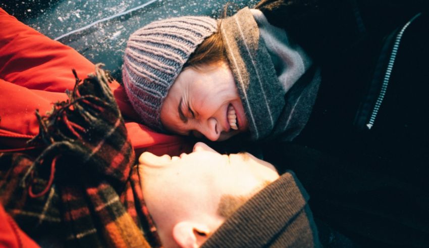 A man and woman are laying on the ground together.