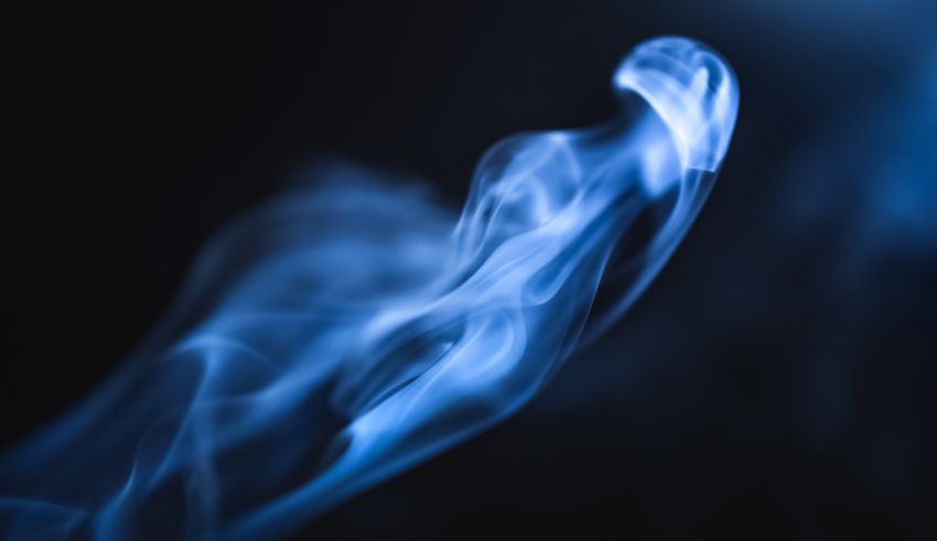 A close up of blue smoke on a black background.