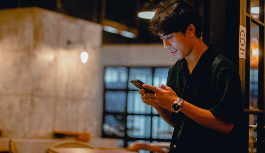 A young man looking at his phone in a restaurant.