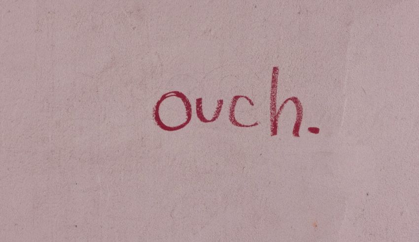 A pink wall with the word ouch written on it.