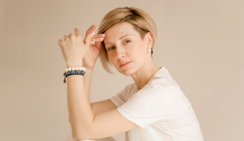 A woman wearing a white shirt and a bracelet.