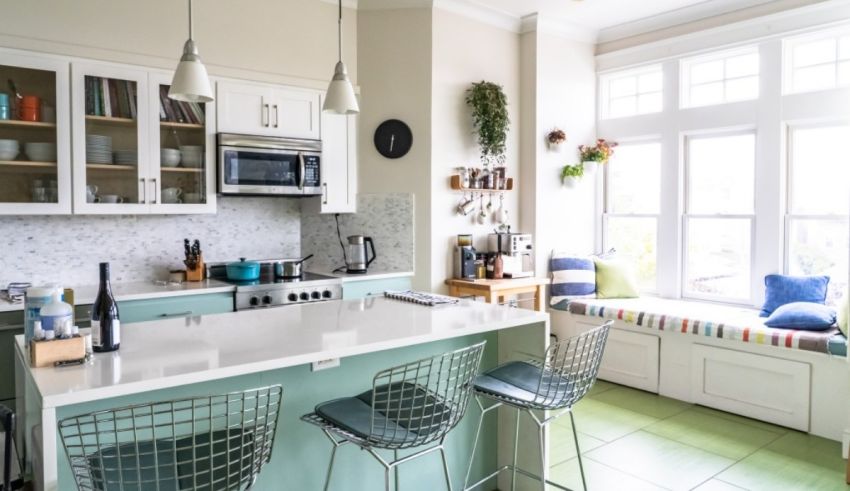 A kitchen with a white countertop and green chairs.