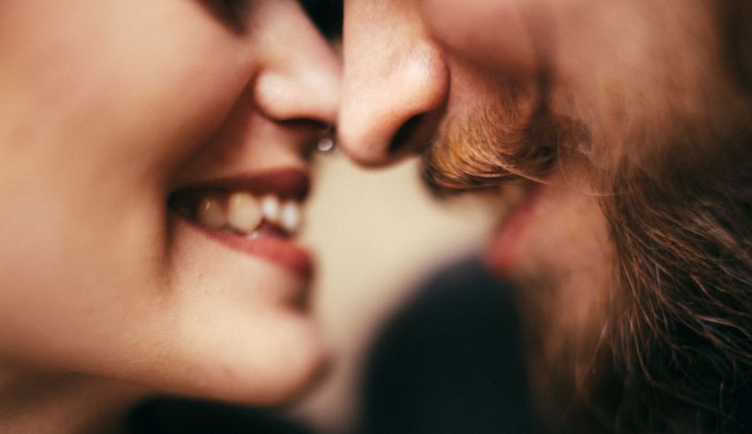 A close up of a man and woman sharing a kiss.