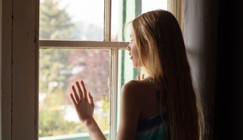 A young woman looking out of a window.