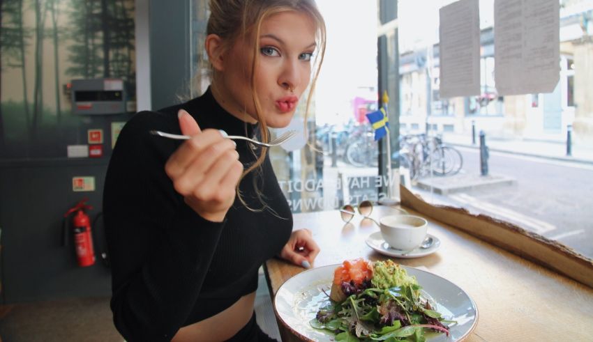 A woman eating a salad in a cafe.