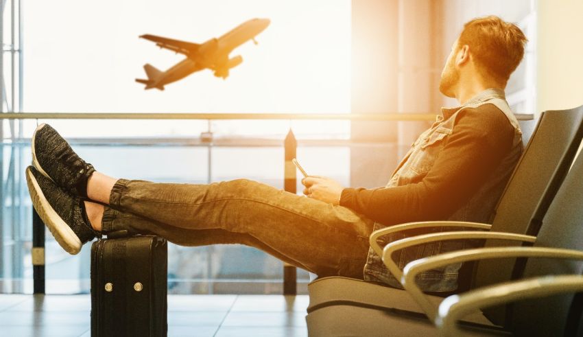 A man sitting in an airport waiting for an airplane.