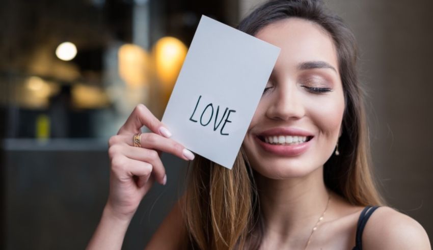 A woman holding up a piece of paper with the word love.