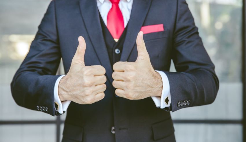 A businessman in a suit giving a thumbs up.