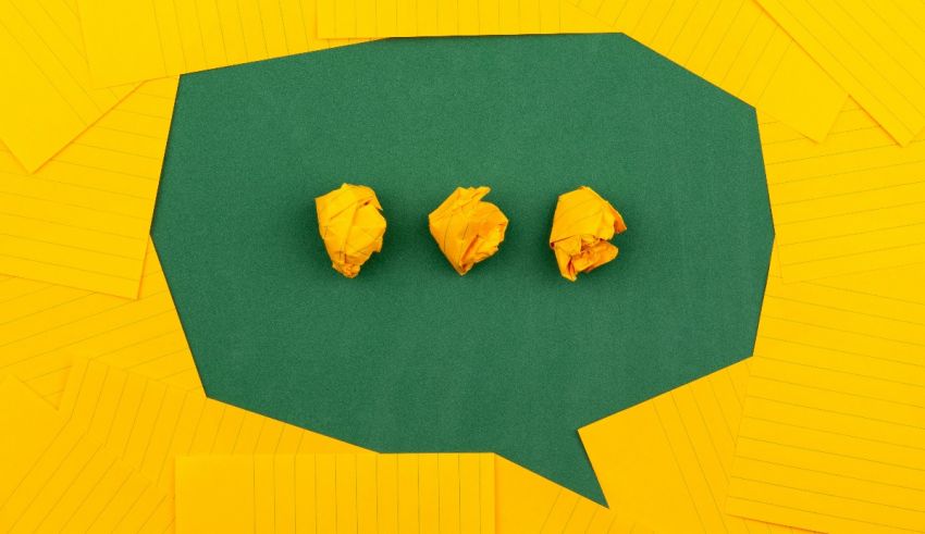 A yellow speech bubble with three yellow pieces of crumpled paper.