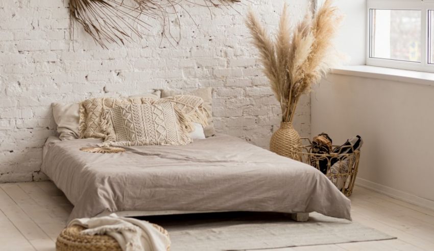 A bed with pillows and a basket of dried plants.