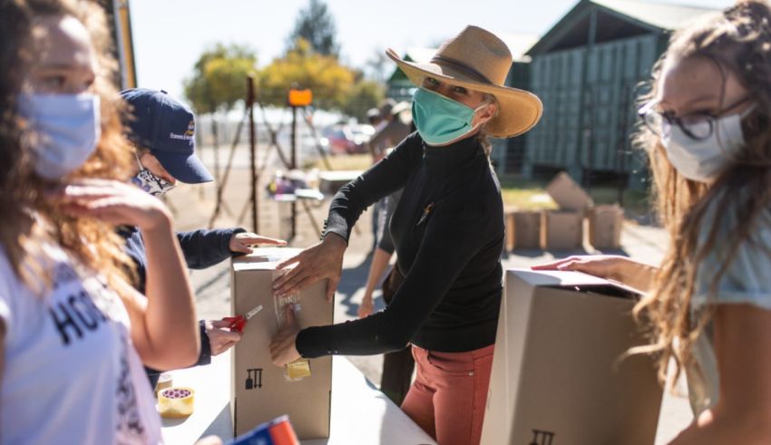A group of people wearing face masks at a food drive.