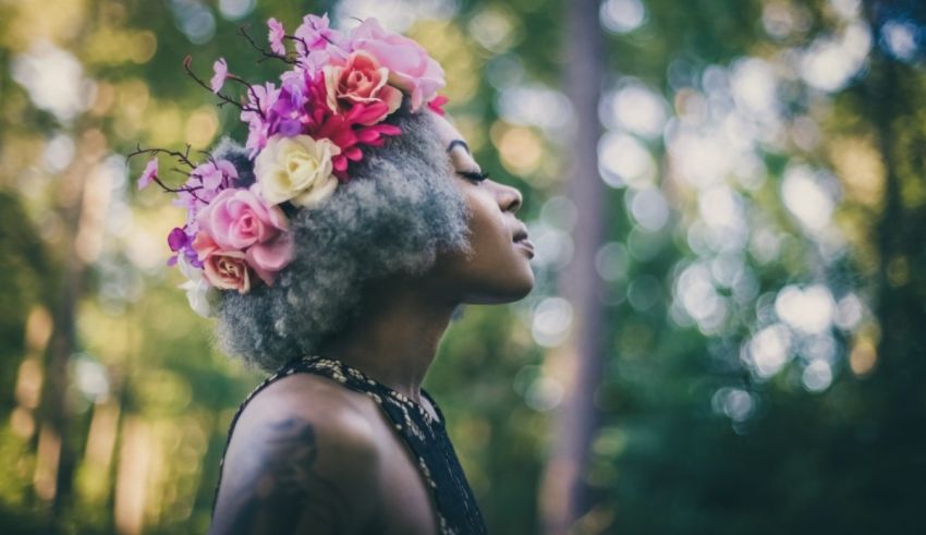 A woman wearing a flower crown in the woods.