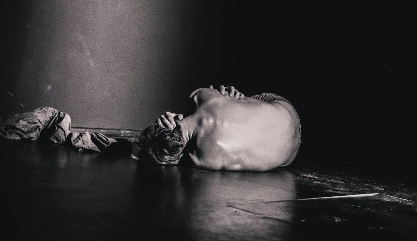 A black and white photo of a person laying on the floor.