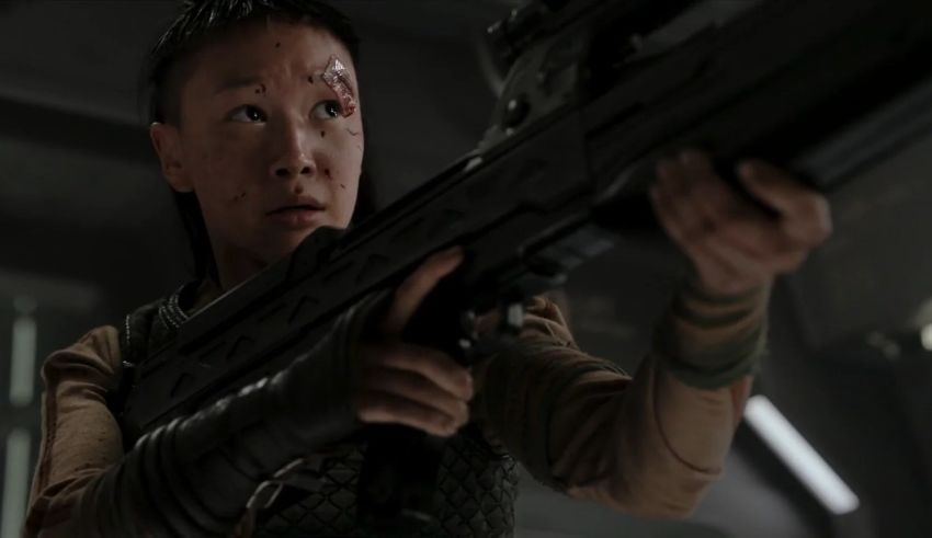 An asian woman holding a rifle in space.