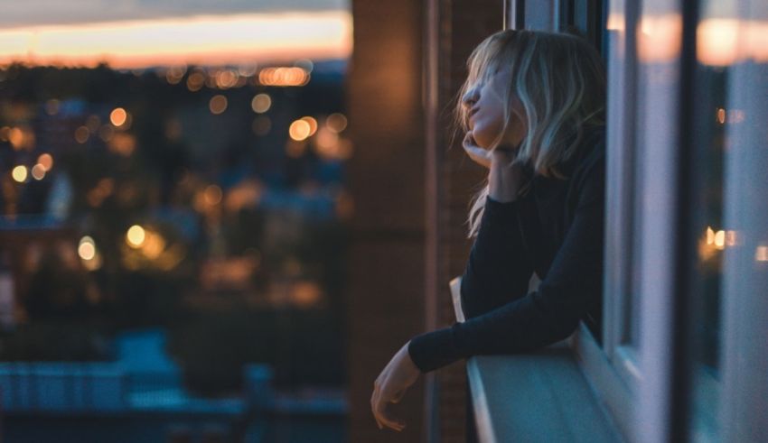 A woman looking out of a window at night.