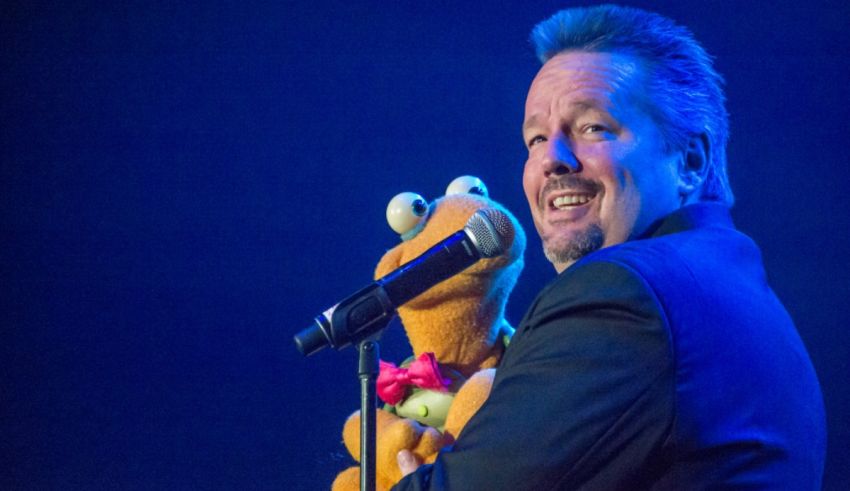 A man with a stuffed animal holding a microphone.
