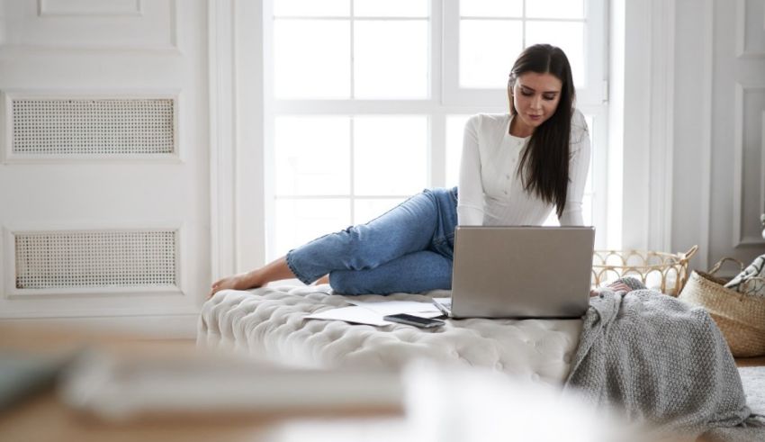 A woman sitting on a couch with a laptop.