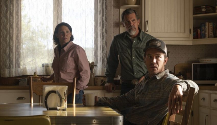 Three people standing at a table in a kitchen.