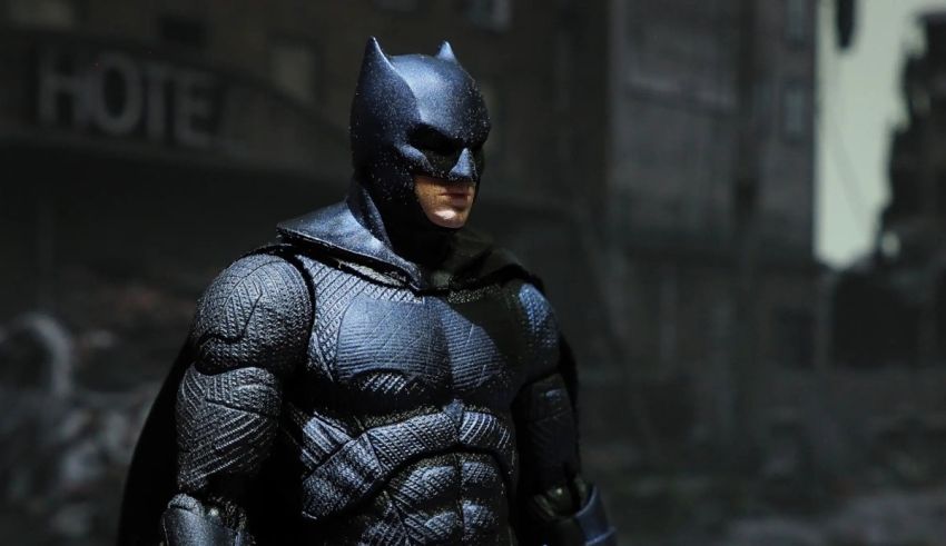 The batman action figure is standing in a city.