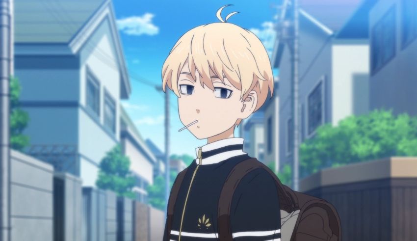 A boy with blonde hair and a backpack is standing in a street.