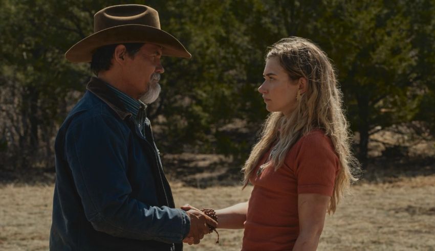 A man in a cowboy hat shakes hands with a woman.