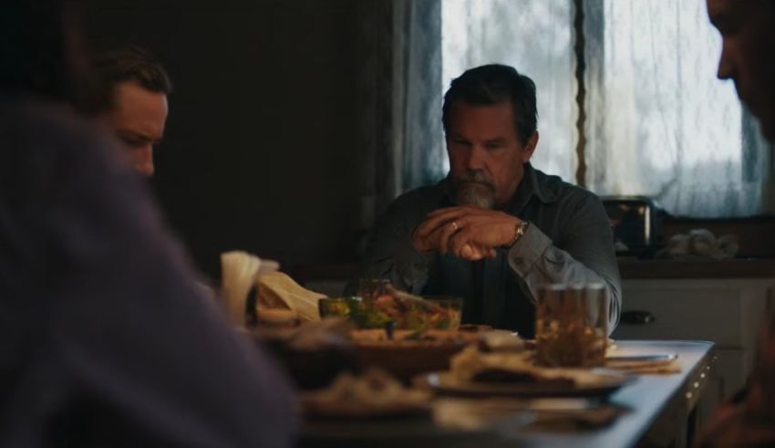 A group of people sitting around a table in a kitchen.