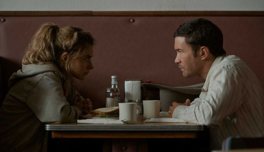 A man and woman sitting at a table in a diner.