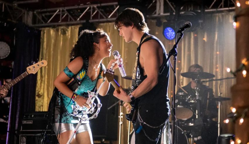 A man and a woman singing on stage with guitars.