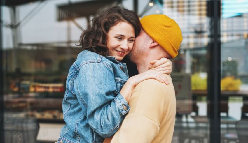 A man and woman hugging in front of a coffee shop.