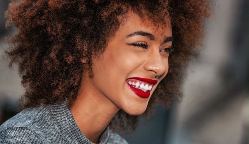 A woman with afro hair smiling.