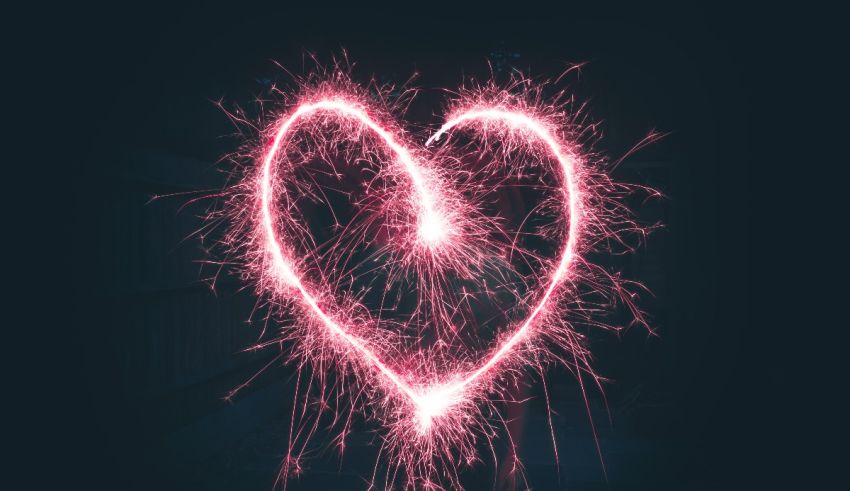 A heart shaped sparkler on a dark background.