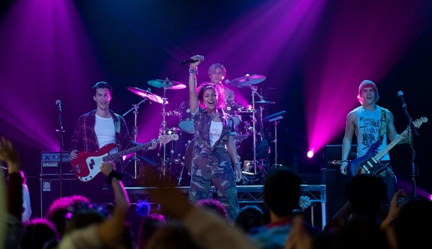 A group of people performing on stage with purple lights.