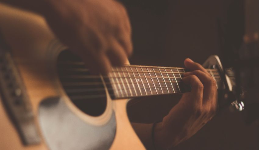 A close up of a person playing an acoustic guitar.