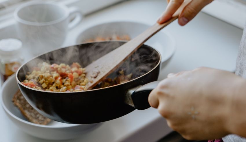 A person cooking food in a pan.