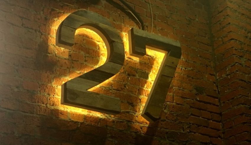 The number 27 is lit up on a brick wall.