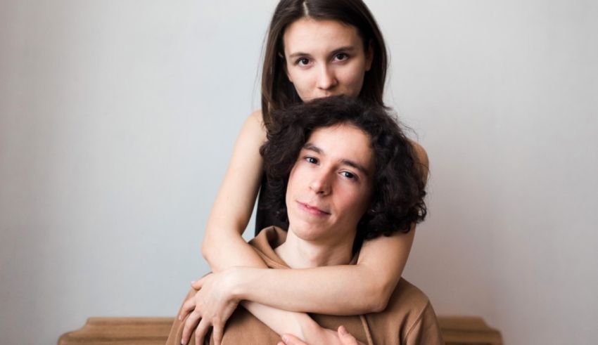 A young man and woman hugging each other on a bench.