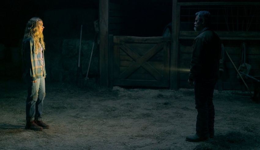 A man and a woman standing in a barn at night.