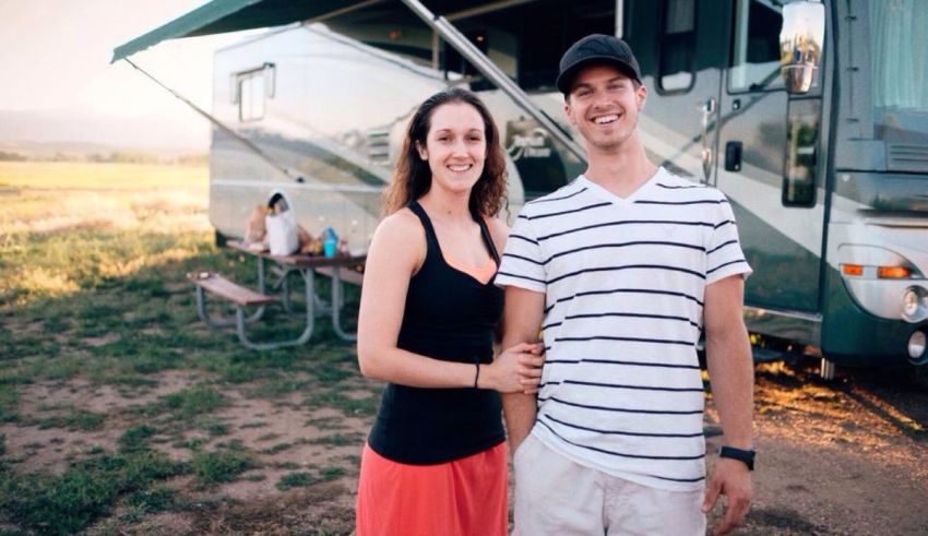 A man and woman standing in front of an rv.