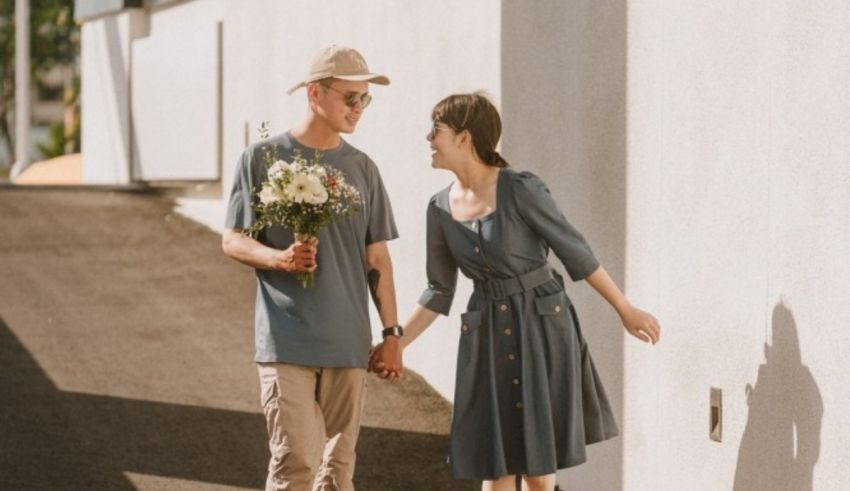 A man and woman holding hands while walking down the street.