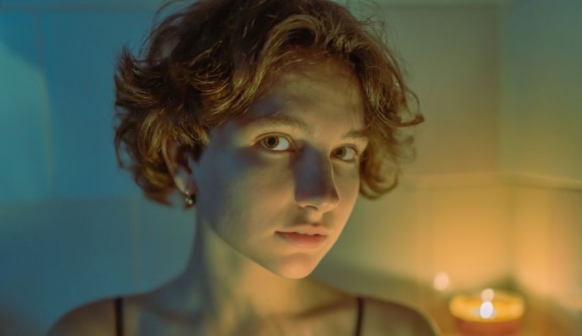 A woman in a bath tub with candles in front of her.