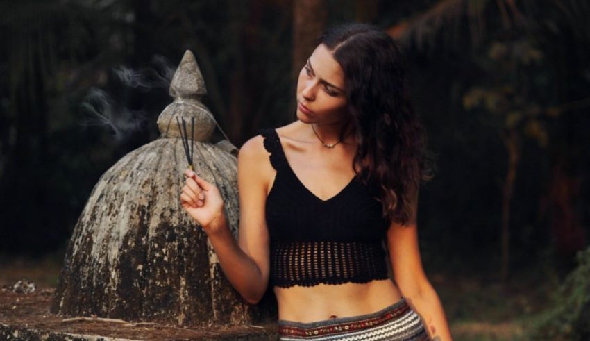 A woman smoking a cigarette in a park.