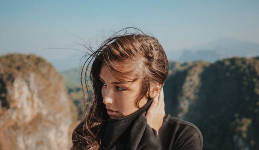 A woman wearing a black sweater on top of a mountain.