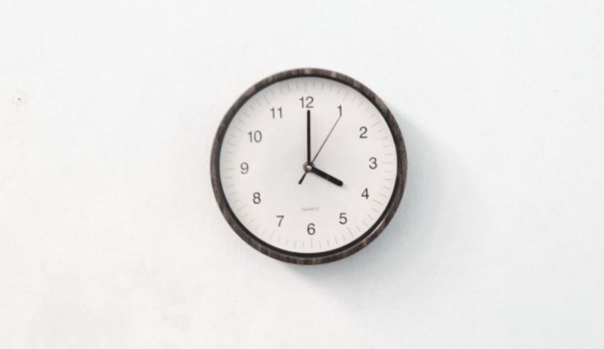 A wall clock hanging on a white wall.