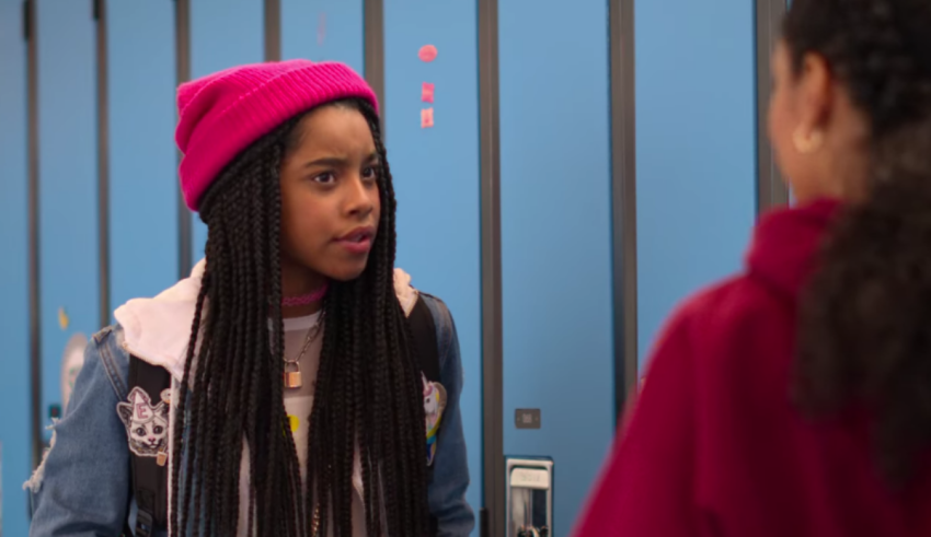 A girl is talking to another girl in a locker room.