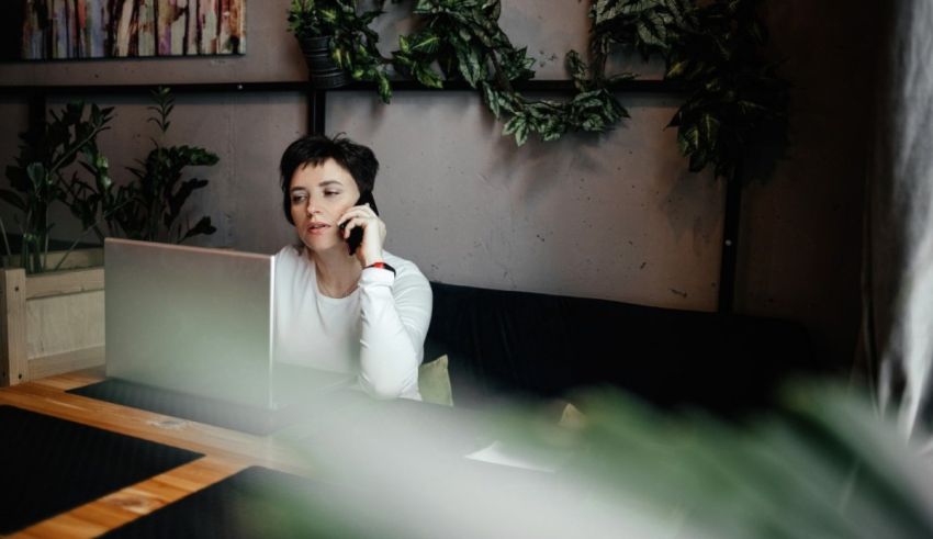 A woman talking on the phone while sitting at a table.