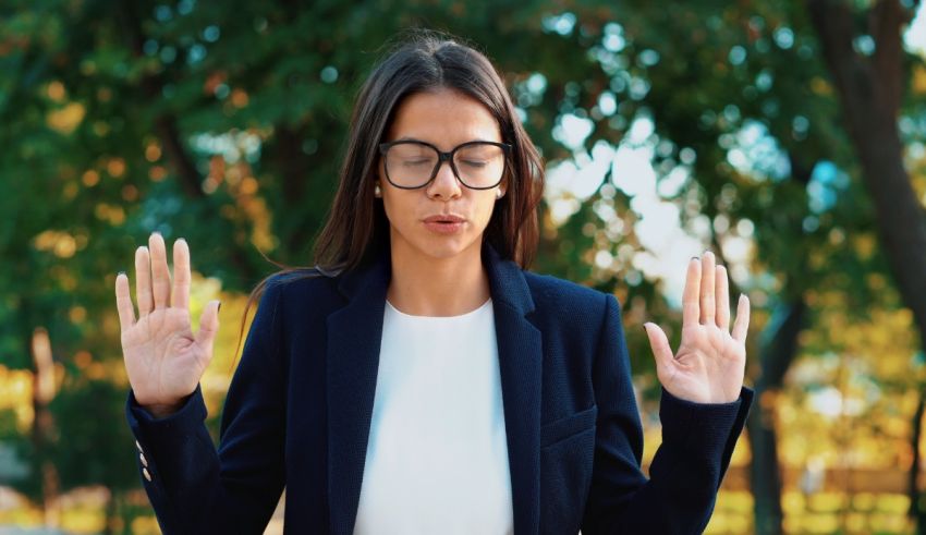 A woman in glasses is making a gesture with her hands.