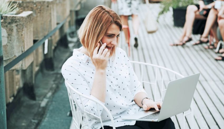 A woman sitting on a chair with a laptop on her lap.